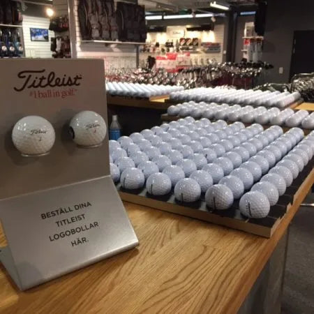 Exempel på golfbollar för tryckeri, upplagda på trä brickor i flera fack