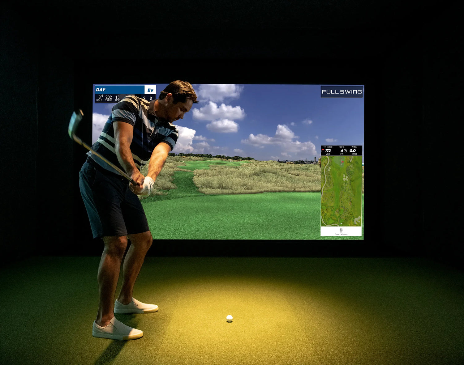 Jason Day spelar golf i en simulator och svingar sin klubba framför skärmen